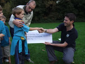 Cheque presented to Andy Woods-Ballard from Global Vision International